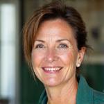 Retrato de Elena Rodríguez, instructora de meditación, sonriendo amablemente.